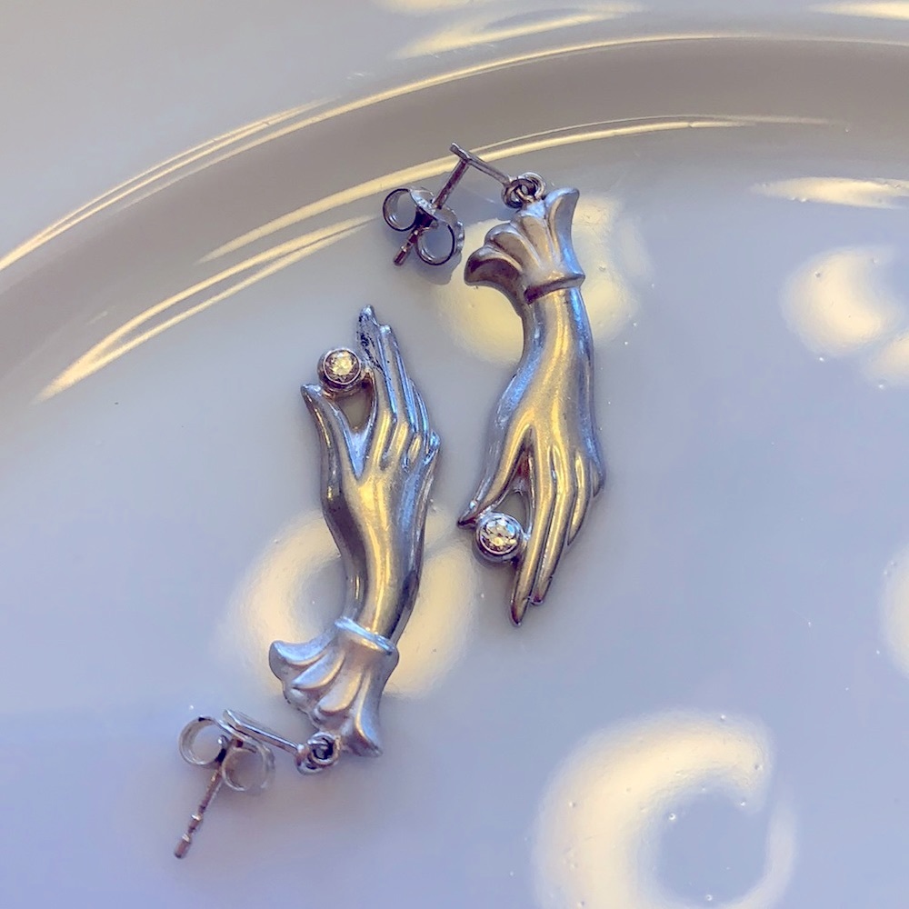 Vintage earrings of a hand holding a “diamond”